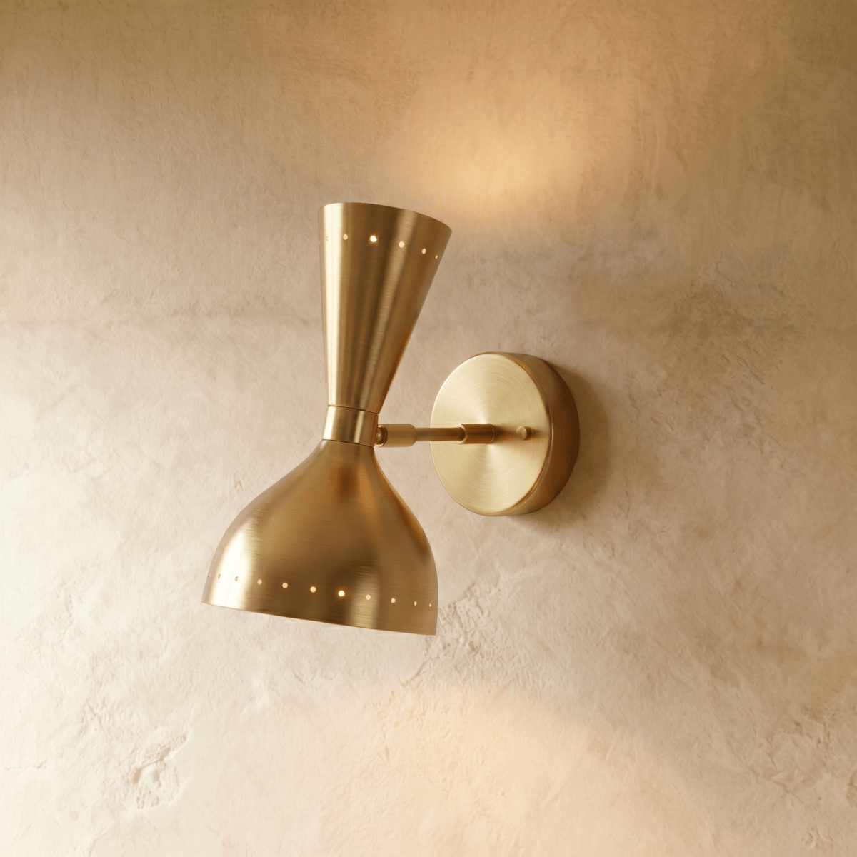 Clérachic wall lamp in brushed brass, an hourglass shade with perforated rims on a round wall plate.