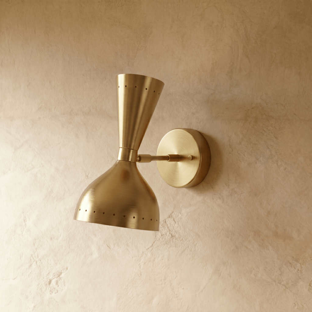 This Clérachic wall lamp in brushed brass viewed close, pinpoints of light rimming both cones.