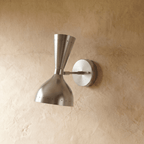 Clérachic wall lamp in chrome shown from another angle, pinpoints of light rimming both cones.