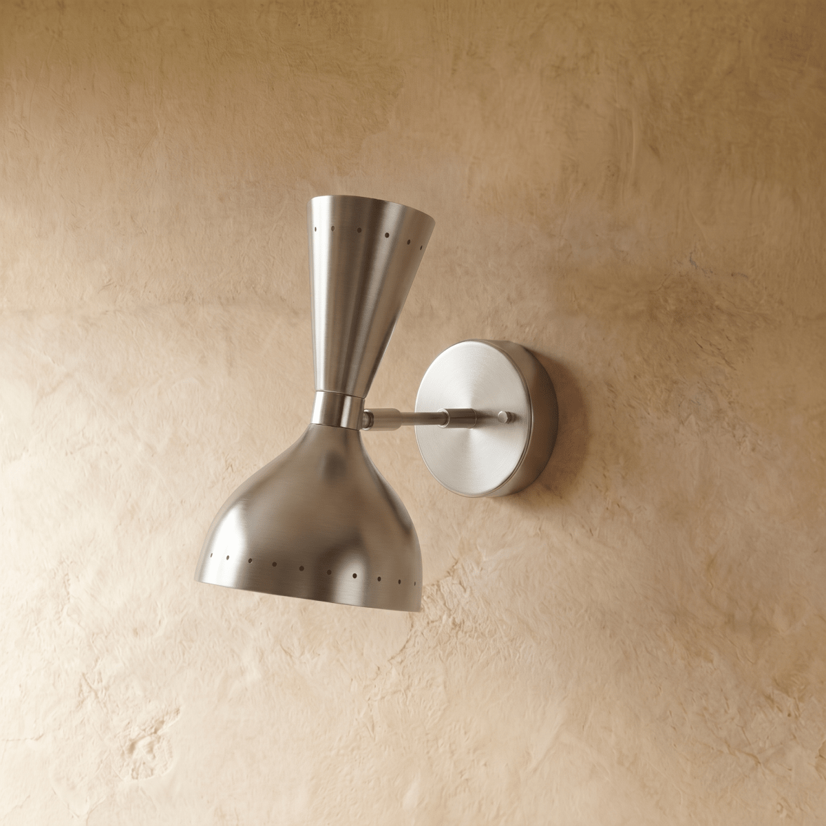 Clérachic wall lamp in chrome shown from another angle, pinpoints of light rimming both cones.