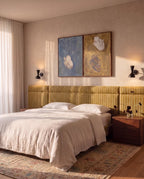 Clérachic wall lamp in matte black, a pair flanking abstract art above a mustard striped headboard.