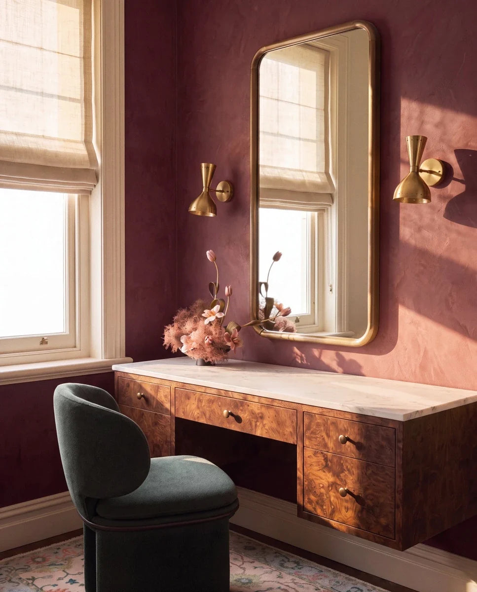 Clérachic wall lamp in brushed brass, a pair flanking a mirror above a burl-wood vanity desk.