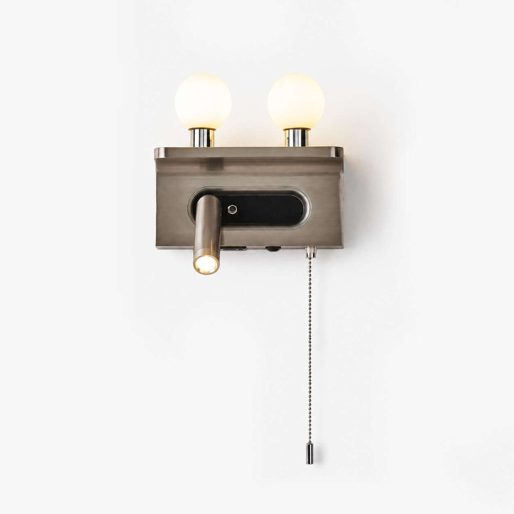 A nickel Clérachic wall light with two frosted glass globes, a small reading spotlight and a pull chain, on a plain white backdrop.