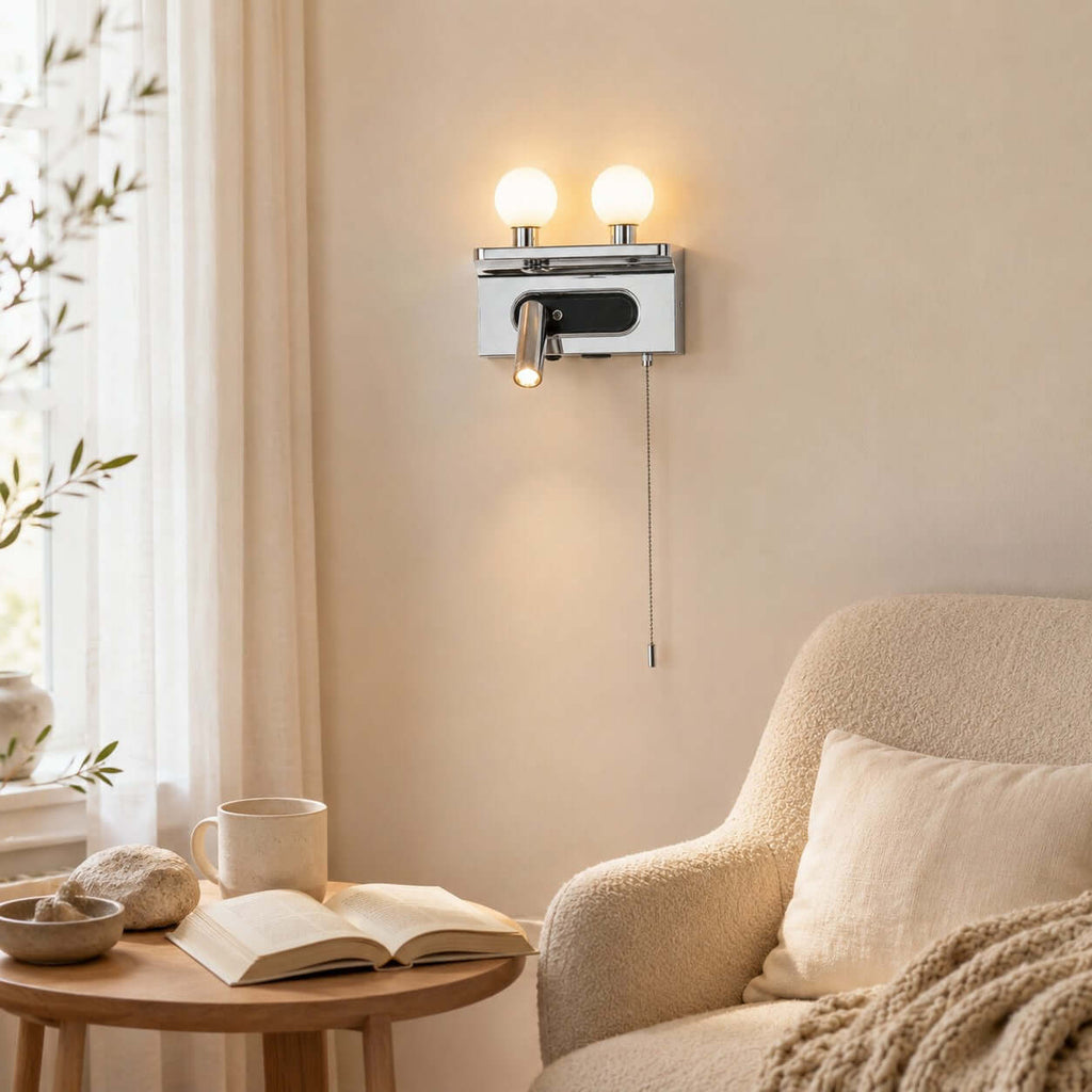 This Clérachic wall light in chrome lights a reading corner with a boucle armchair, a round table and an open book.