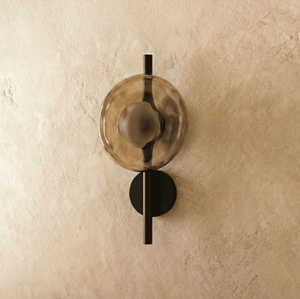 Clérachic wall light with an amber glass disc, switched off, on a slim black rod and small round backplate.