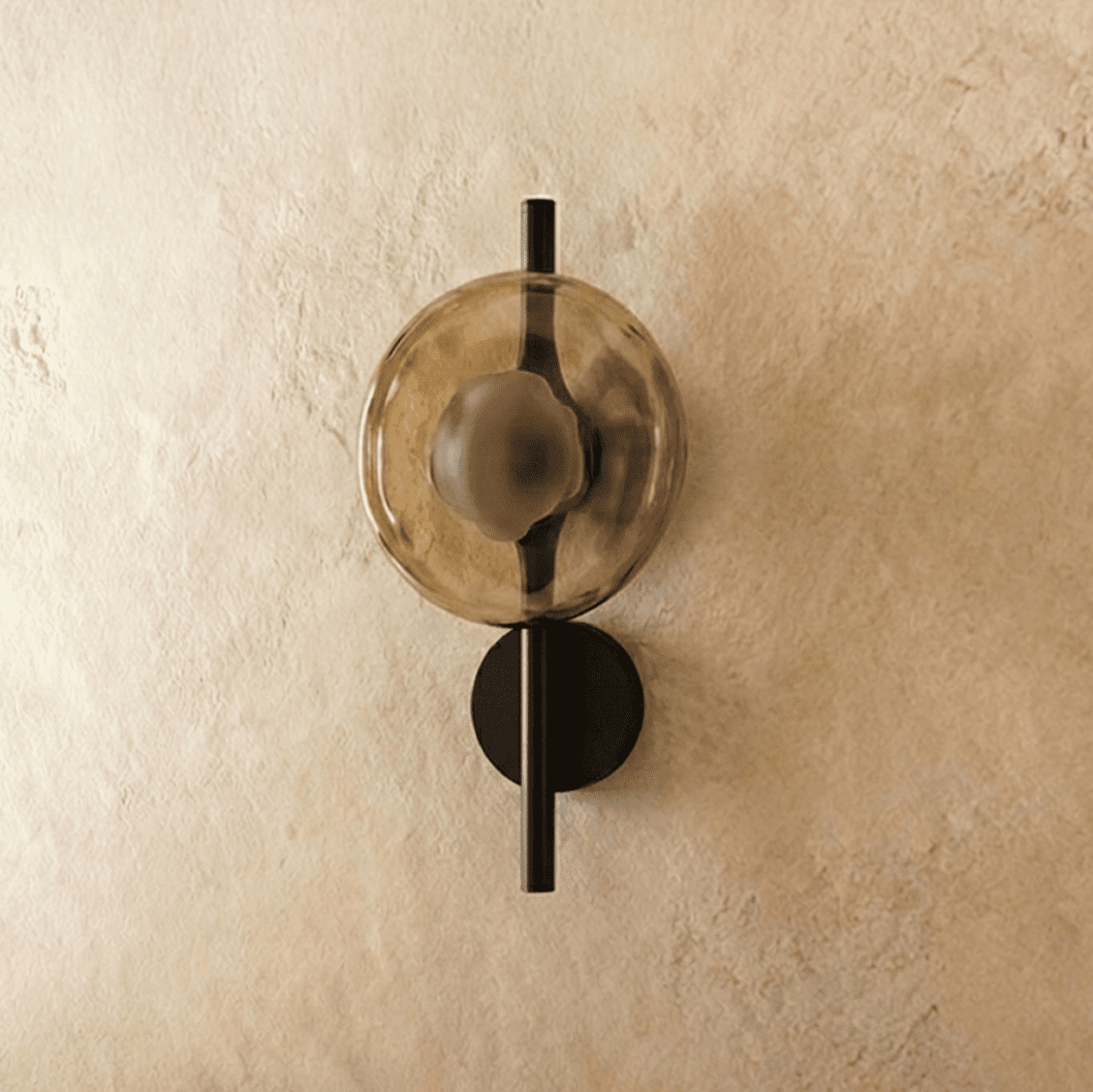 Clérachic wall light with an amber glass disc, switched off, on a slim black rod and small round backplate.