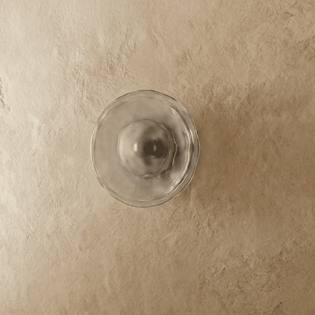 Clérachic flush wall light with a clear rippled glass disc and a dark bulb at its centre, switched off on plaster.
