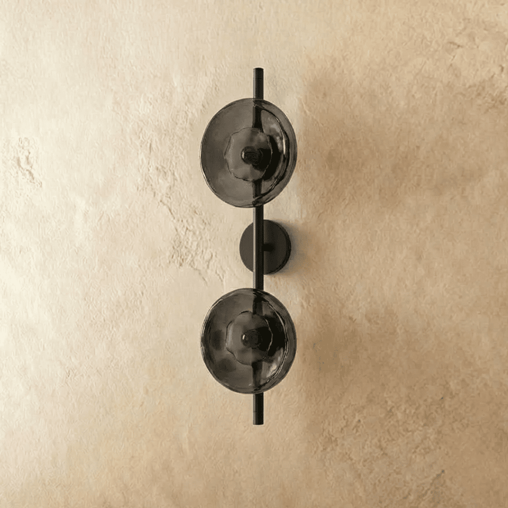 Clérachic two-shade wall light with smoky grey glass discs on a black vertical rod and backplate, switched off.