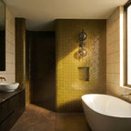 Clérachic two-shade wall light with smoky glass discs on a vertical rod, mounted on a glossy olive tiled wall beside a window.