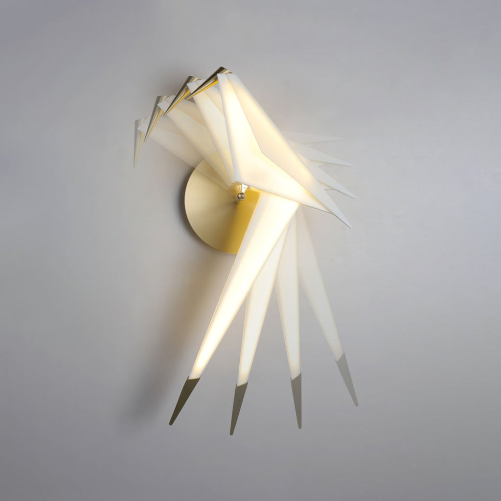 A multiple-exposure view of this Clérachic bird wall light swinging from side to side on its gold perch against a grey wall.