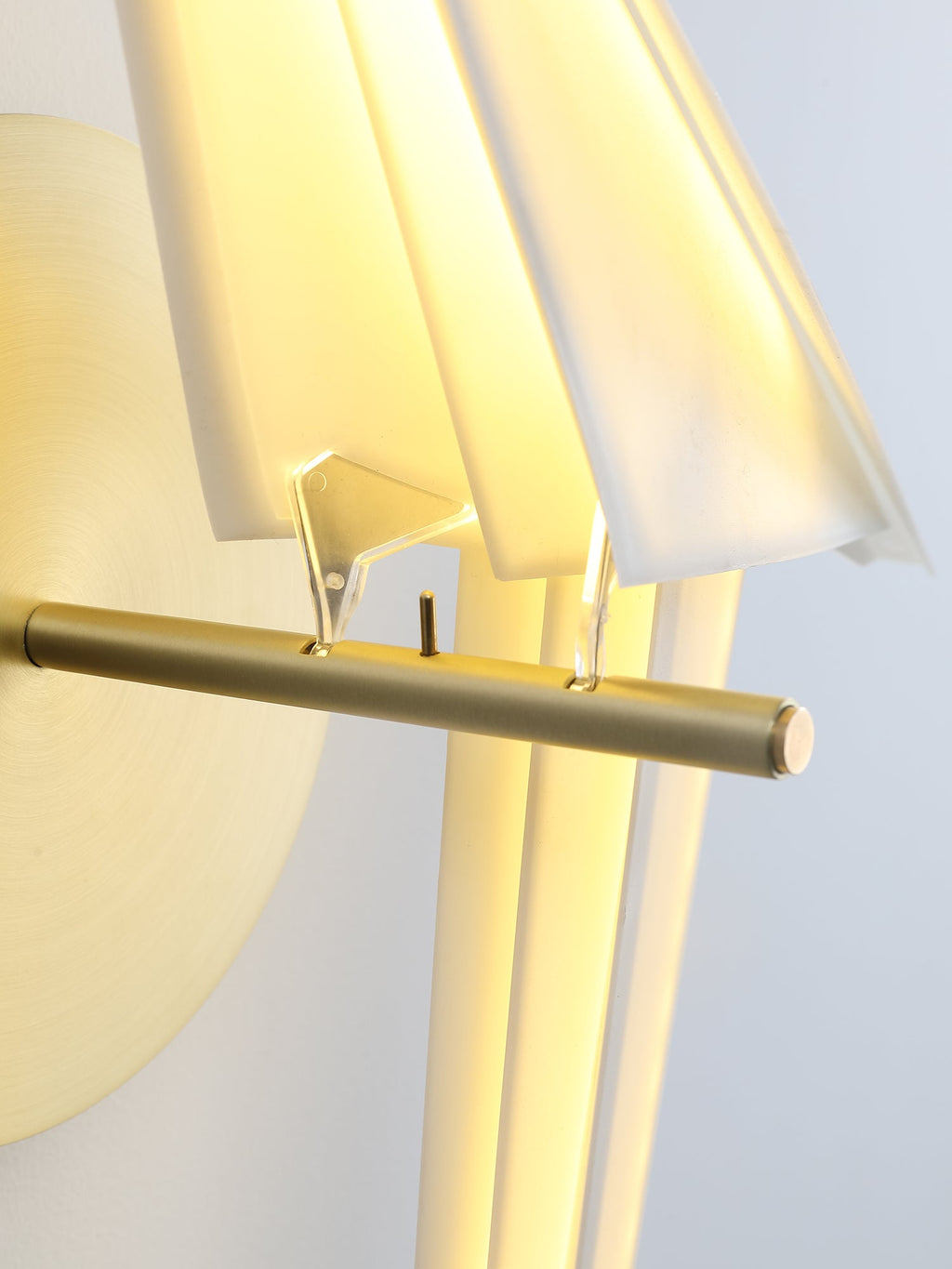 Close view of the gold perch bar and the clear fixings holding the folded white body of this Clérachic bird wall light.