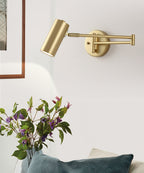This Clérachic gold wall light beside a vase of purple flowers, with a framed picture and a blue cushion below.