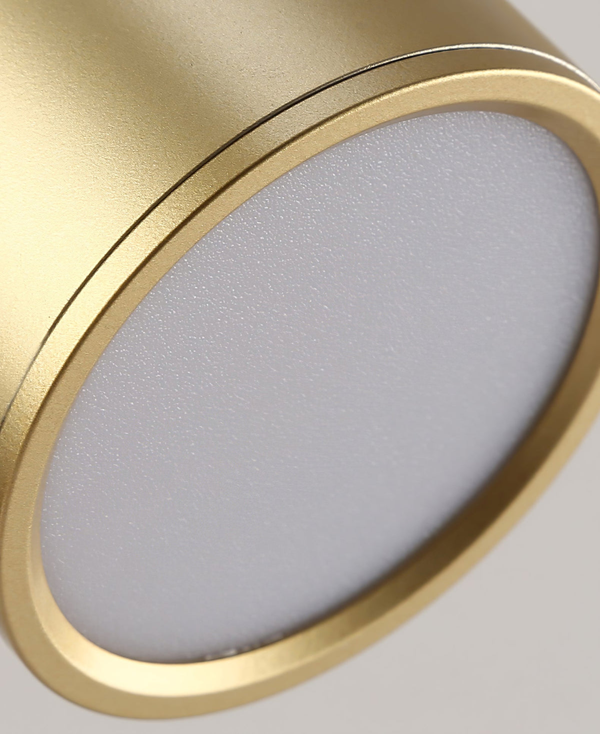 Close view of the frosted lens in the head of this Clérachic gold wall light, with a thin brass rim.