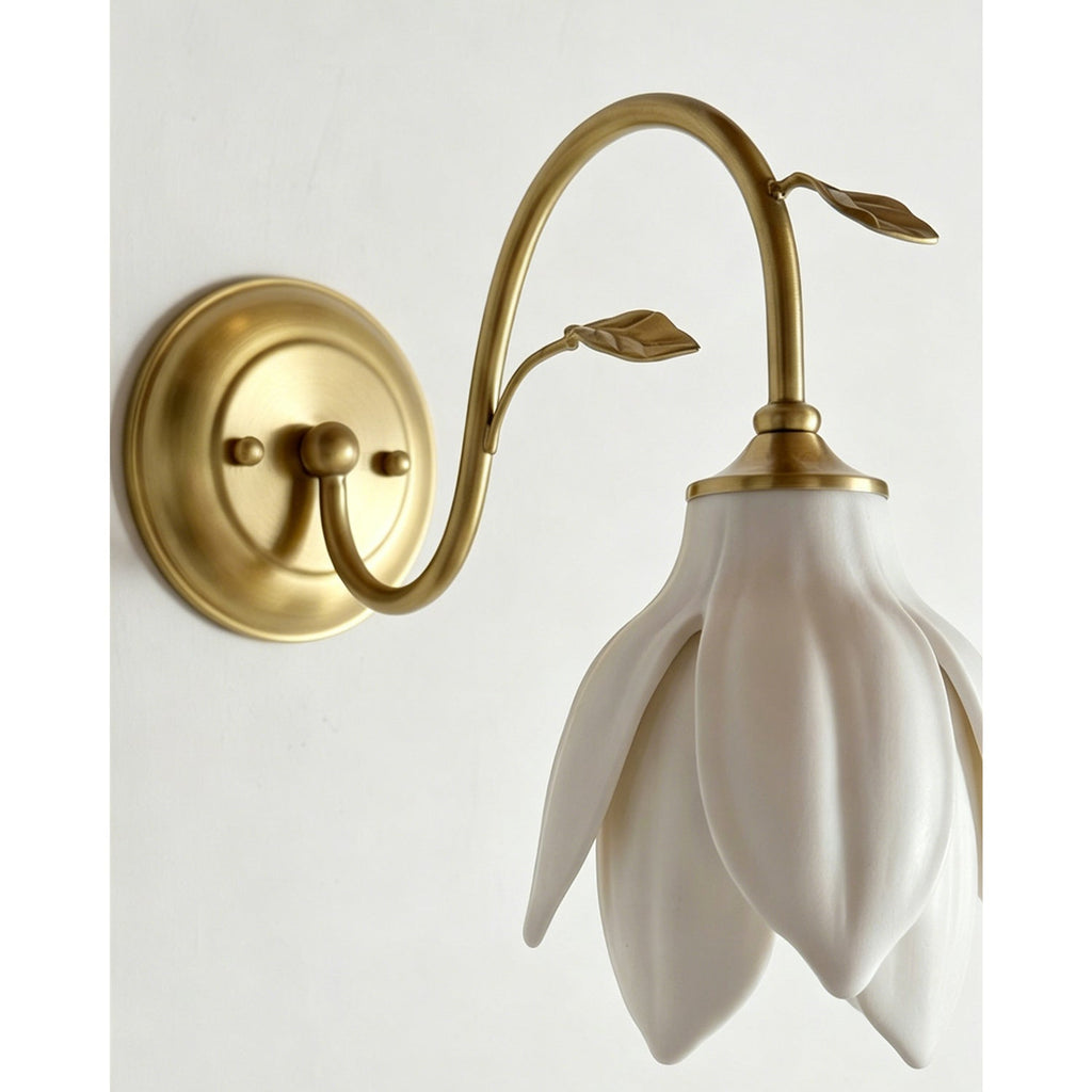 Close view of the layered ceramic petals and the brushed gold arm with its leaf details on this Clérachic wall light.