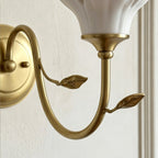 Close view of the gold collar under the shade and the two small leaves on the curved arm of this Clérachic wall light.