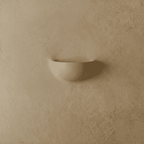 Clérachic half-moon plaster wall light switched off, a smooth matte shell mounted flat on a warm beige limewash wall.