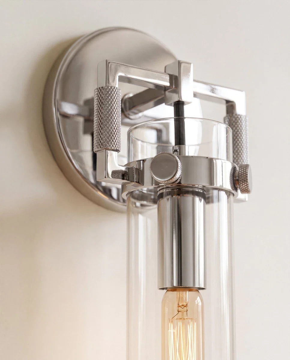 Clérachic close view of the polished chrome sconce, its knurled thumbscrews, square bracket and amber filament bulb.