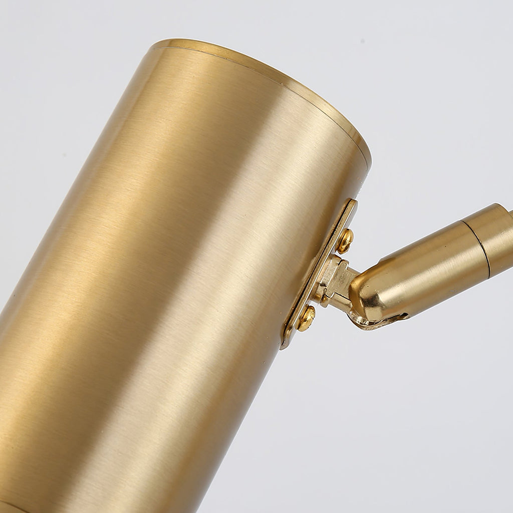 Close view of the brushed gold cylinder head and its swivel joint on this Clérachic swing-arm wall light.