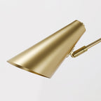 Close view of the brushed gold conical shade of this Clérachic wall light, showing its pale gold interior.