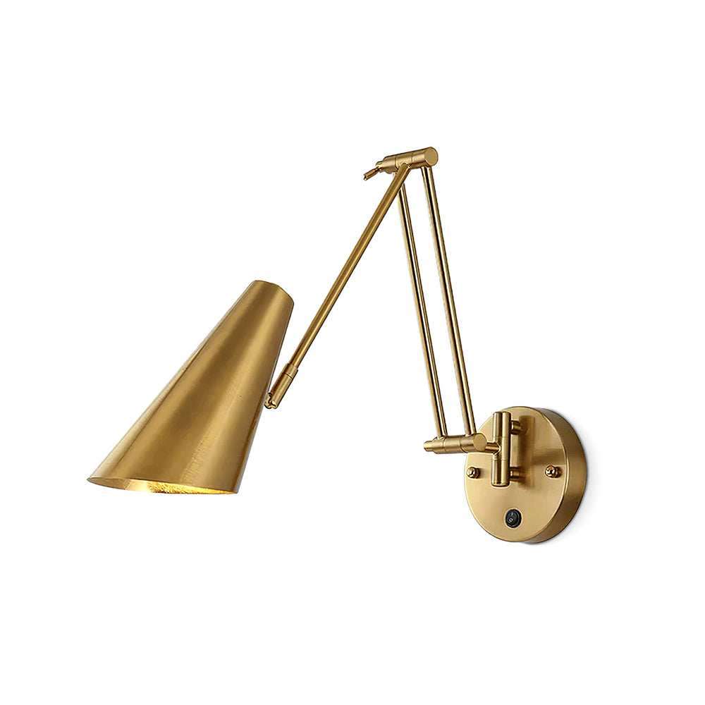Clérachic gold wall light with a conical shade reaching to the left from a round backplate with a small switch, on white.