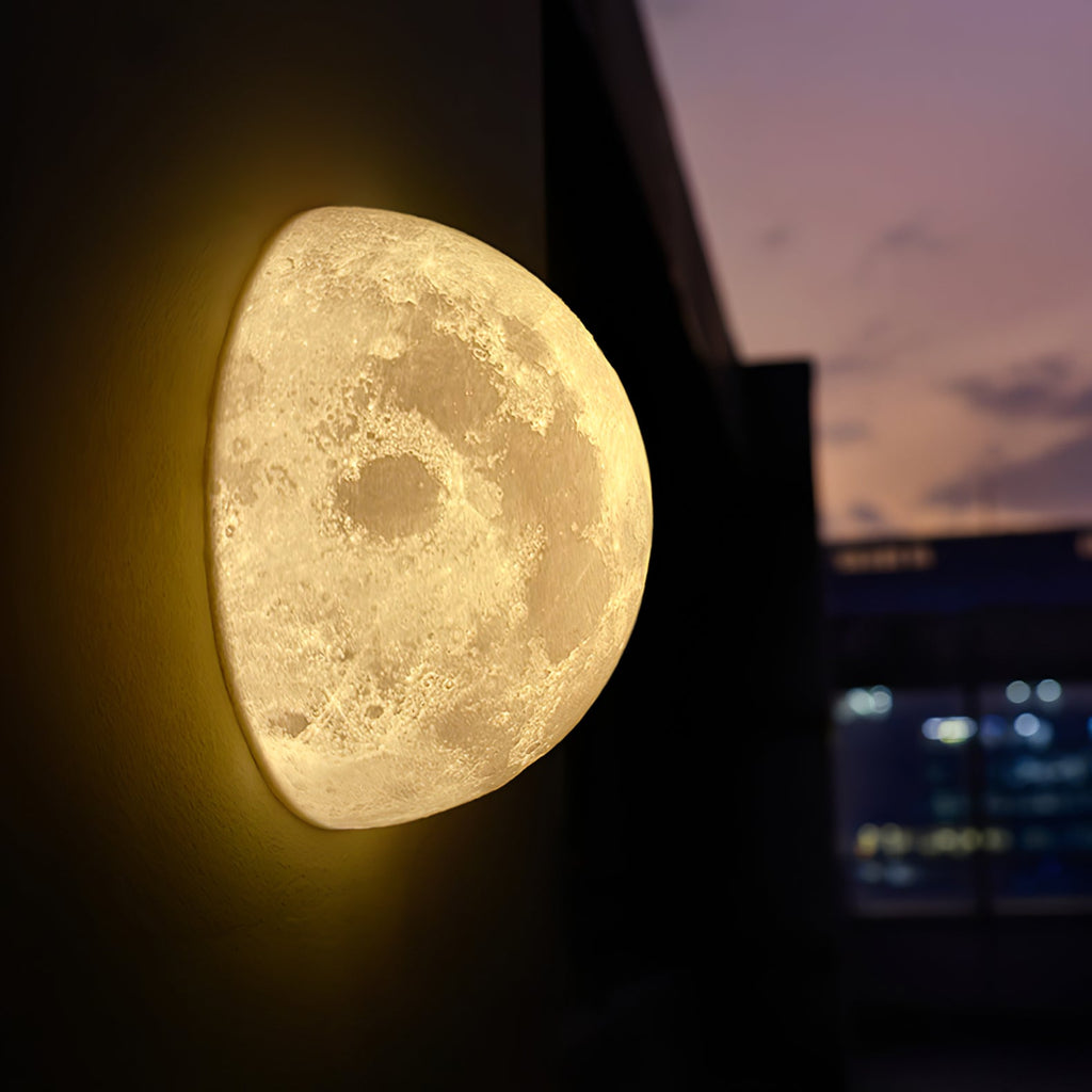 Clérachic half-moon wall light glowing on a dark wall against a pink dusk sky and distant city lights.
