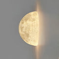 Clérachic half-moon wall light on a grey wall, with a warm glow spilling from the flat edge.