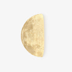 Clérachic half-moon wall light on a plain white backdrop, shown from the front with its cratered, warm-white surface.