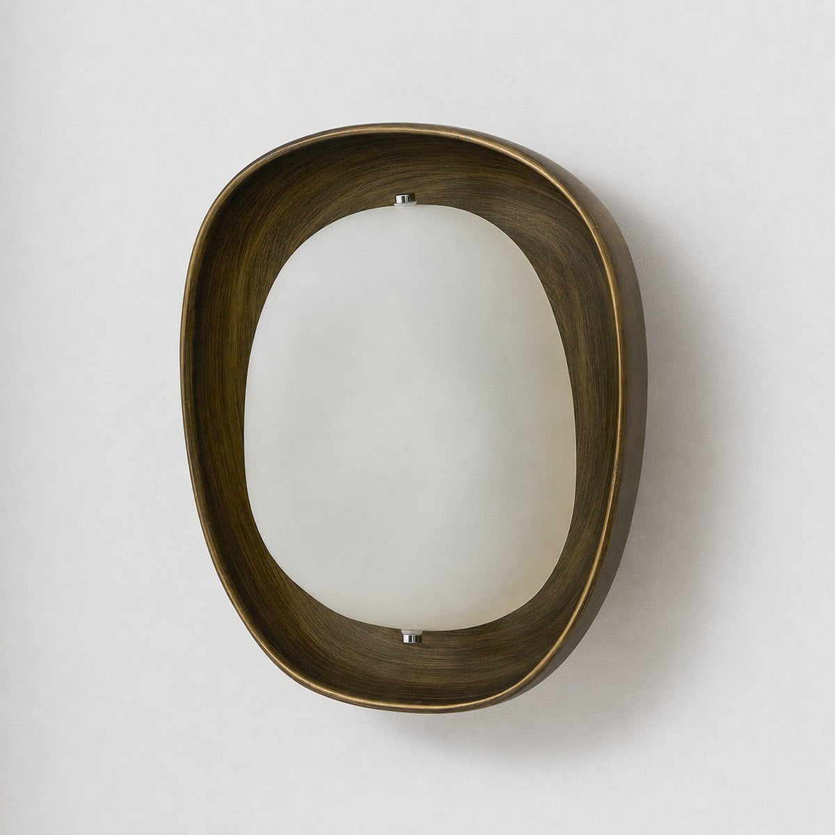 Close view of this Clérachic wall light switched off, with a brushed bronze rim and a smooth frosted shade held by two small screws.