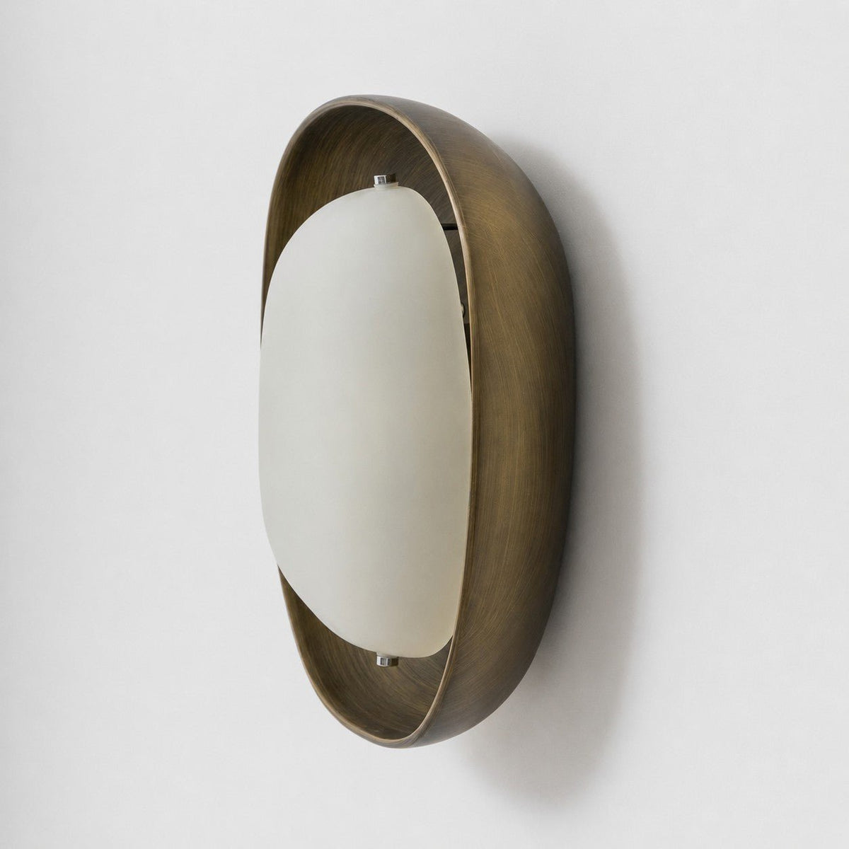 This Clérachic wall light is seen from a steep side angle, showing the depth of the bronze bowl and the curve of the frosted shade.