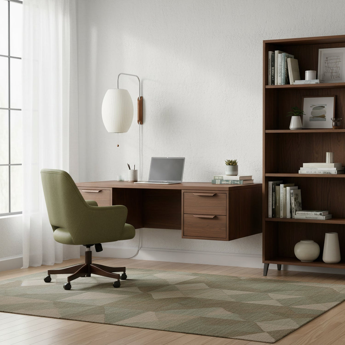Oval white shade of this Clérachic wall light beside a window, with a walnut desk, a green office chair and a tall bookcase nearby.