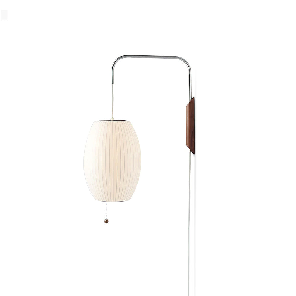 Narrow view of this Clérachic wall light with a pale oval shade hanging from the steel arm, its cord and cable falling to the bottom.