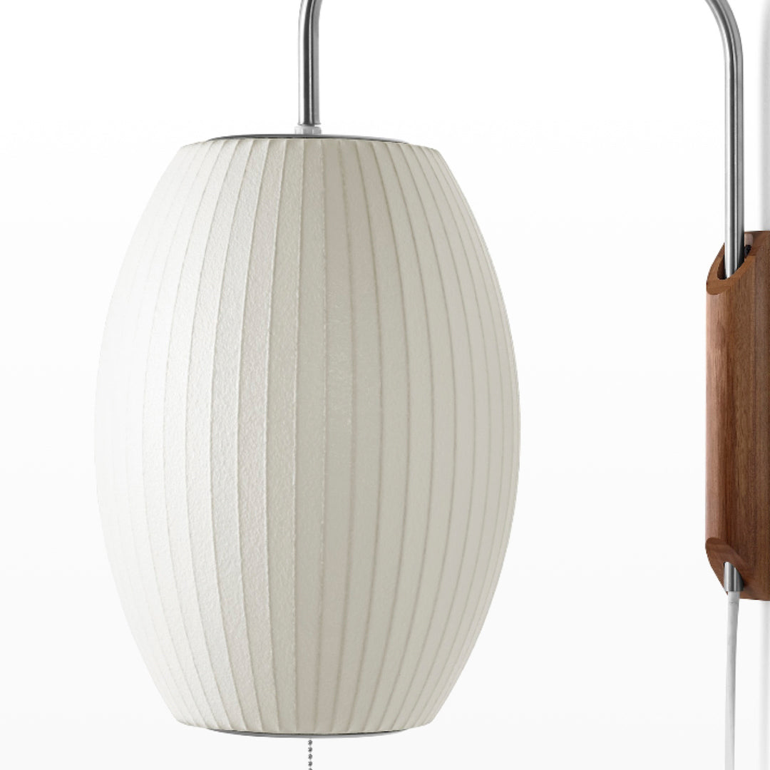 Close view of the fine ribbed texture on the oval shade of this Clérachic wall light, with part of the walnut bracket at the edge.