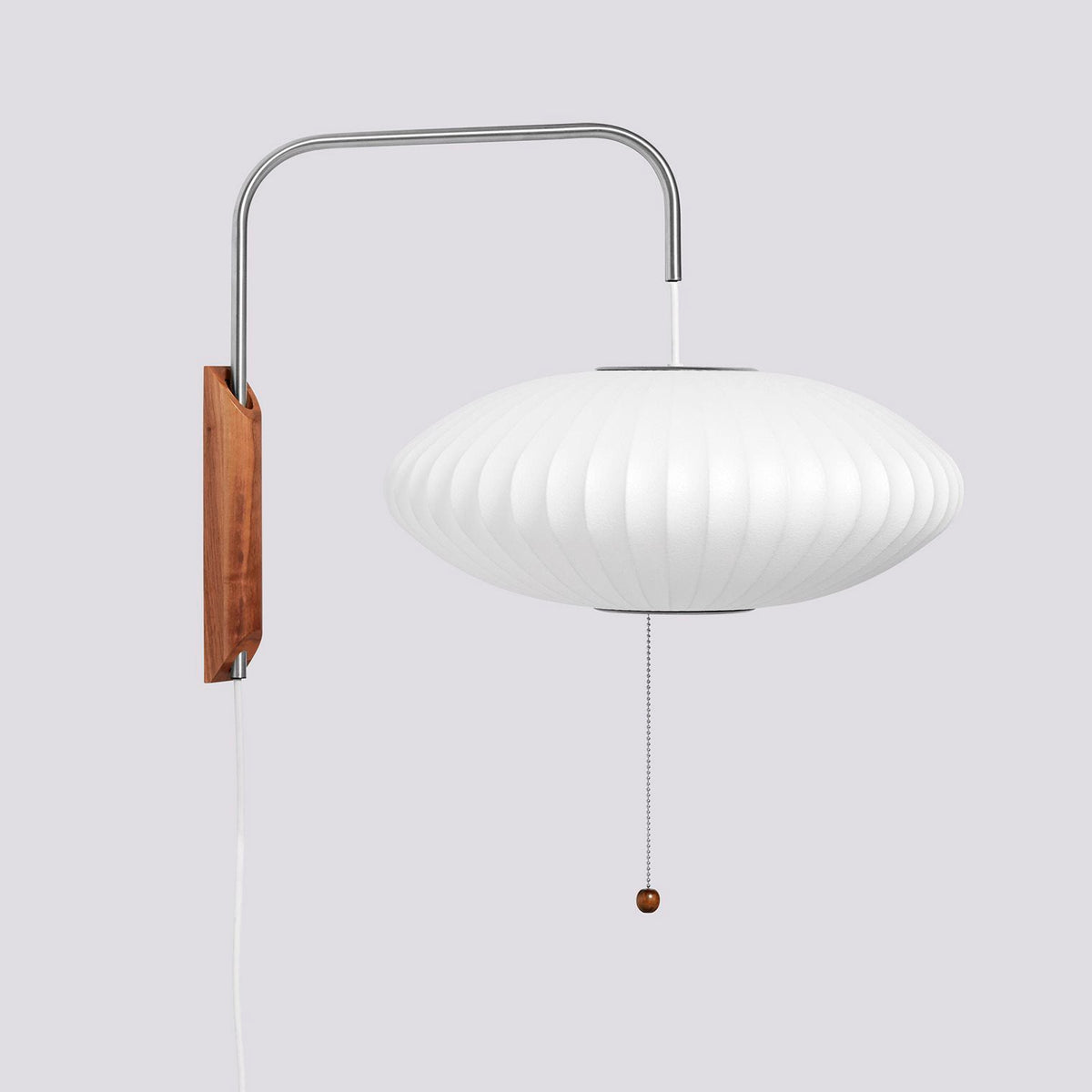 Wide saucer-shaped white shade on a Clérachic wall light with a walnut bracket and bead pull, on a light grey backdrop.
