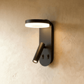 Clérachic matte black wall reading light with a lit circular LED ring above a swivelling tube spotlight and two switches.