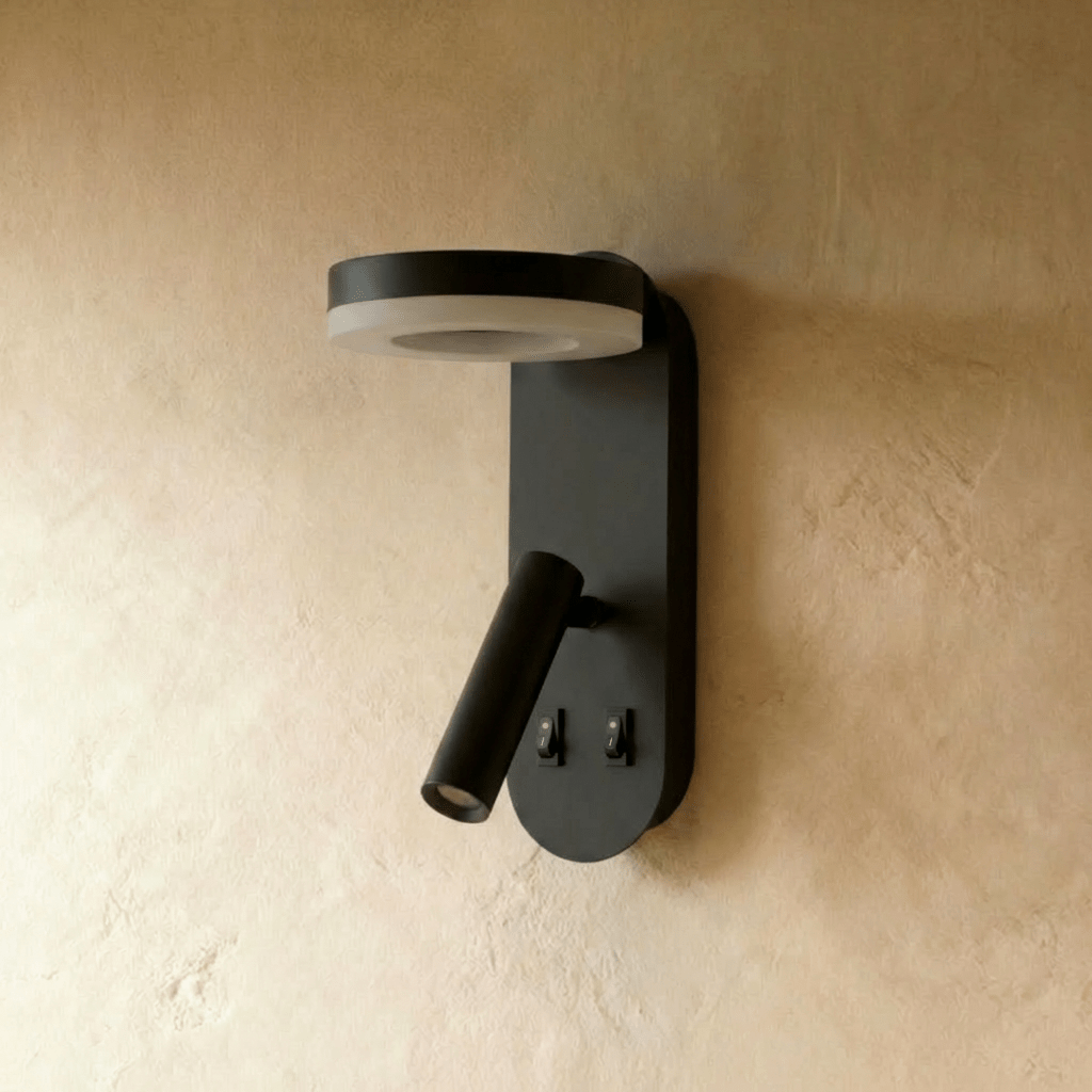Clérachic matte black wall reading light unlit on limewash, showing its flat ring panel, tube spotlight and two switches.