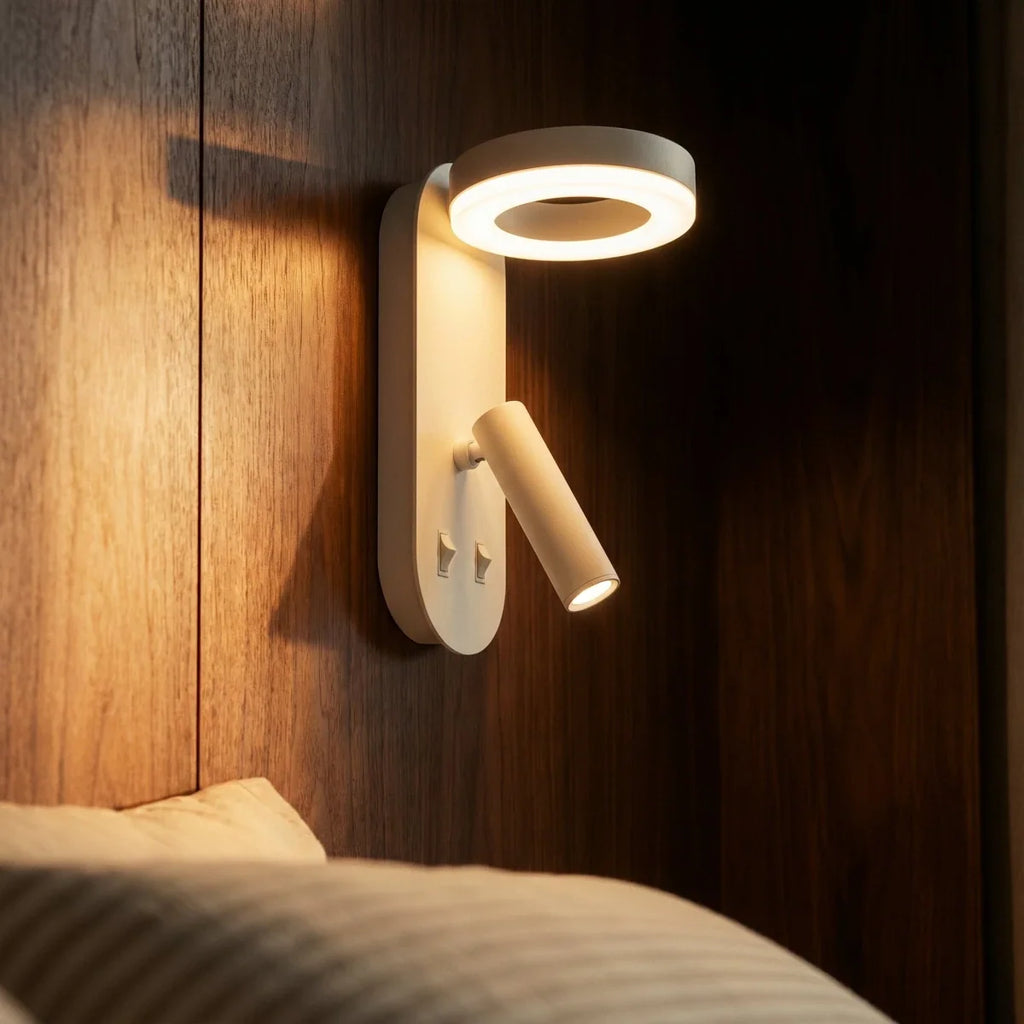 Close view of the Clérachic white wall reading light, its LED ring glowing above the tube spotlight and two switches.