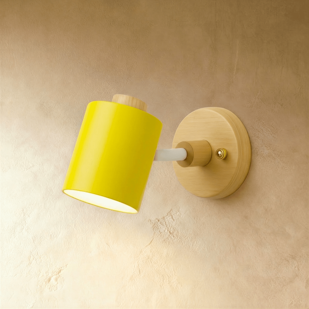 Clérachic wall lamp with a bright yellow cylindrical metal shade and white arm on a pale wood backplate, on a limewash wall.
