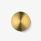 Round brushed brass wall light from Clérachic, with a fine circular grain radiating from the centre, on a plain white backdrop.