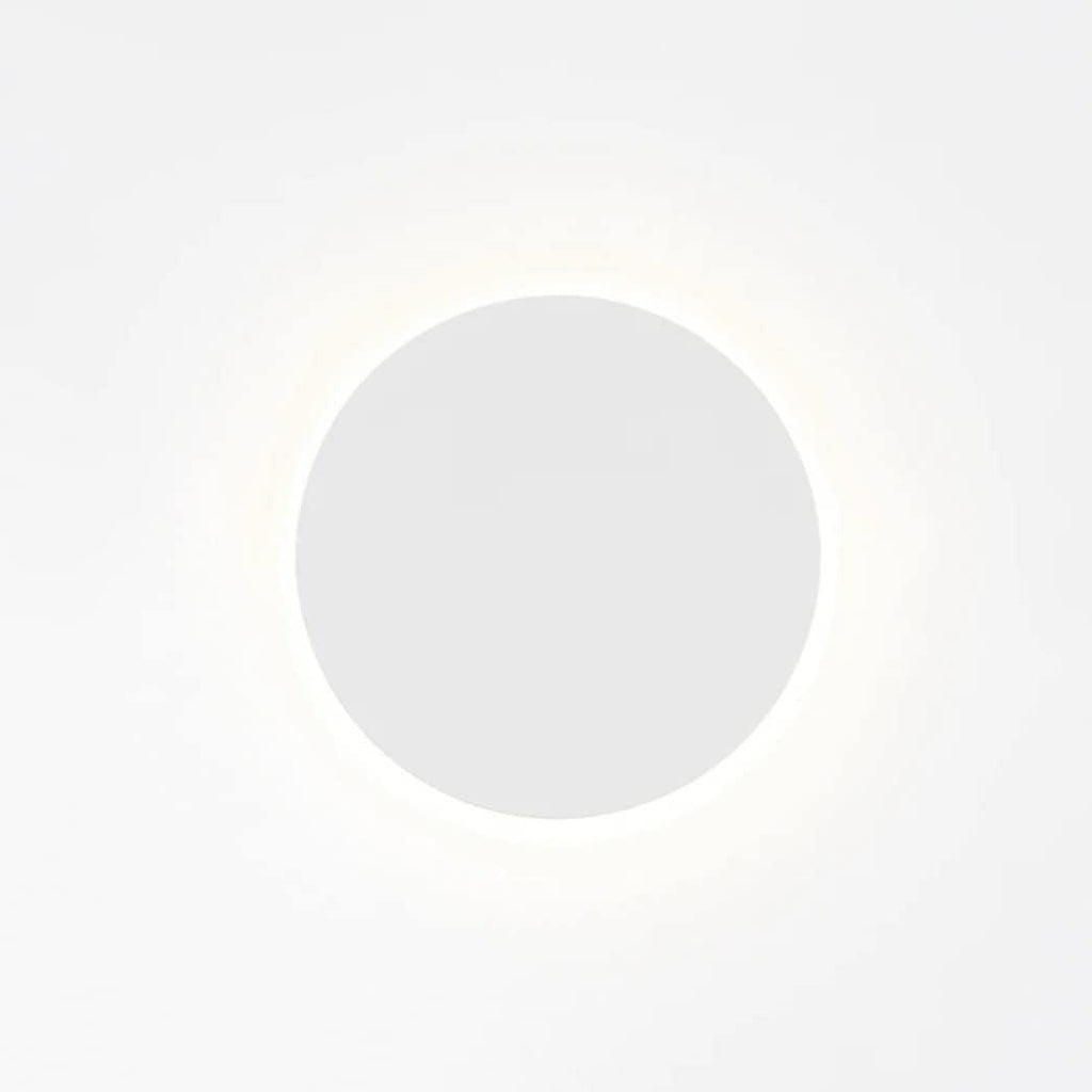 White round Clérachic wall light on a bright backdrop, with a faint glow circling the disk.