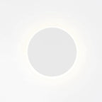 White round Clérachic wall light on a bright backdrop, with a faint glow circling the disk.