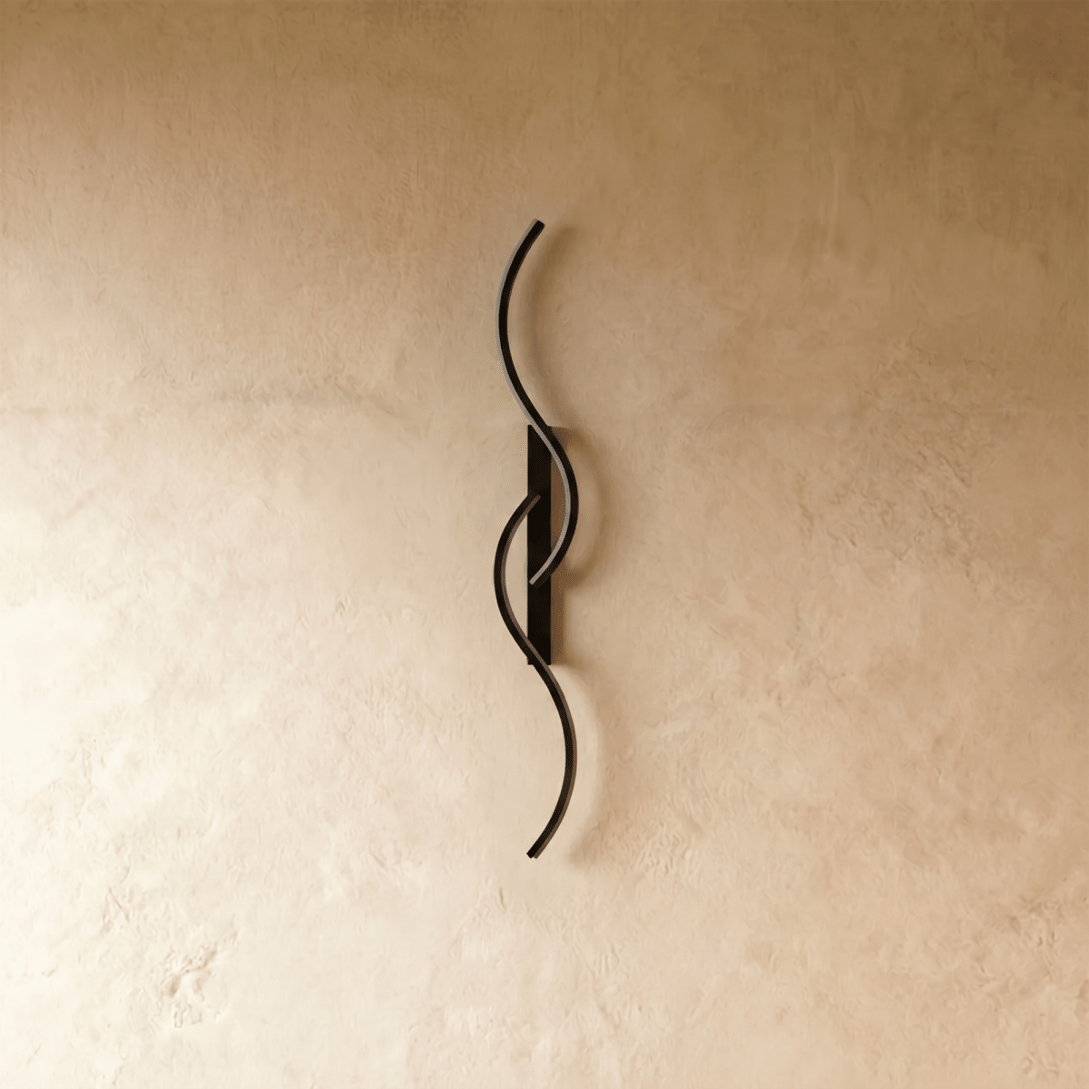 Clérachic S-shaped wall light in matt black with two interlocking curves and a slim backplate, switched off against pale plaster.