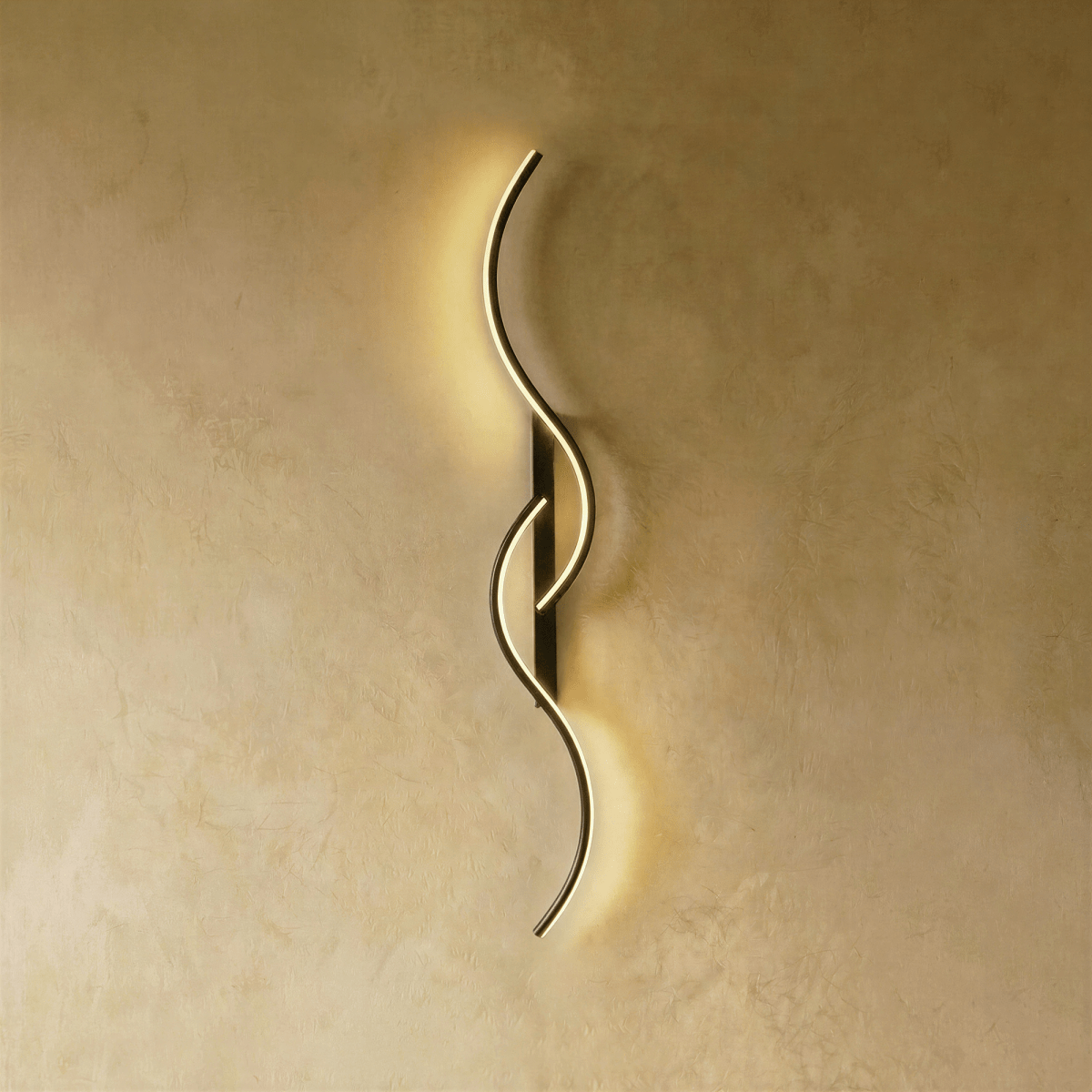 Clérachic black S-shaped wall light with slim interlocking LED curves and a narrow backplate, lit softly on warm plaster.