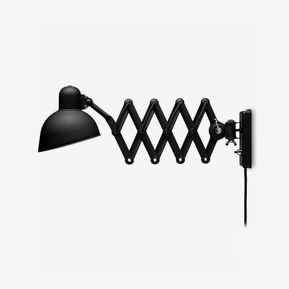 Black Clérachic scissor-arm wall light with a domed shade and a plug-in cord, shown on a plain white background.