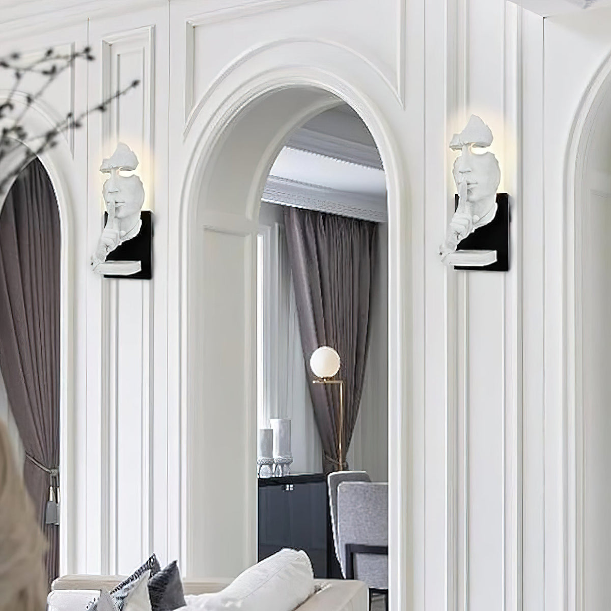 Pair of white Clérachic face wall lights flanking an arched doorway in a white panelled hallway.