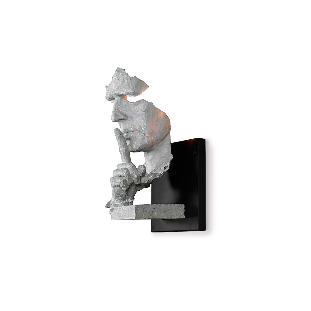 White Clérachic wall light, unlit, with the sculpted face and hand shown against a plain white background.