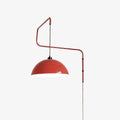Red swing-arm wall light with a zigzag stem, a black counterweight on the wall bracket and a domed shade, this Clérachic wall light on a white backdrop.