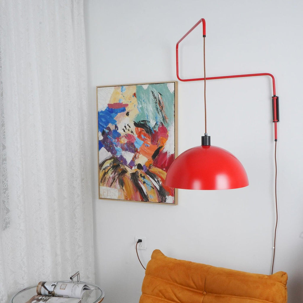 Red shade of this Clérachic wall light swung to the right of an abstract painting, the zigzag arm clear against a white wall.