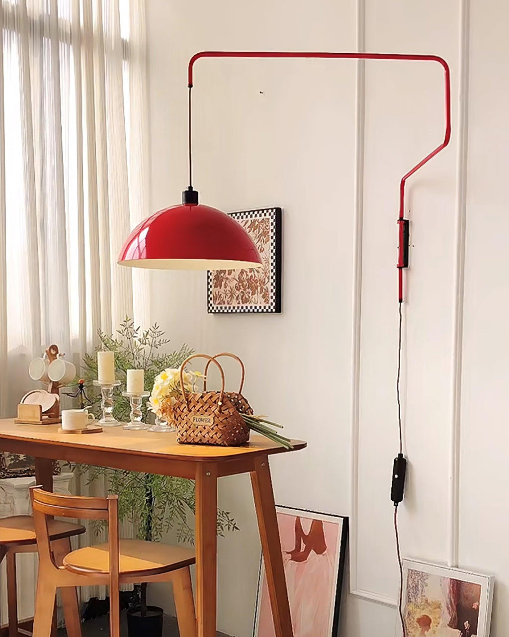 Red shade of this Clérachic wall light above a wooden console table with candles and a flower basket in a bright room.