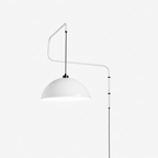 White swing-arm wall light with a domed white shade and a black cable, this Clérachic wall light on a plain white backdrop.