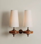 Cream fabric shades and walnut wood bases on a Clérachic twin wall sconce, shown on a soft grey wall with bronze stems.